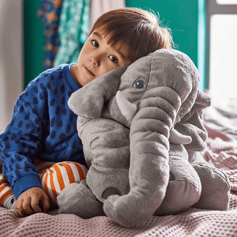 peluche éléphant avec un enfant qui se repose dessus