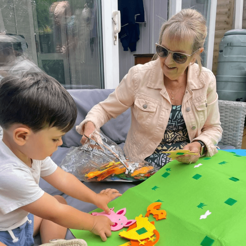 Une mamie qui joue avec son petit fils au tableau interactif